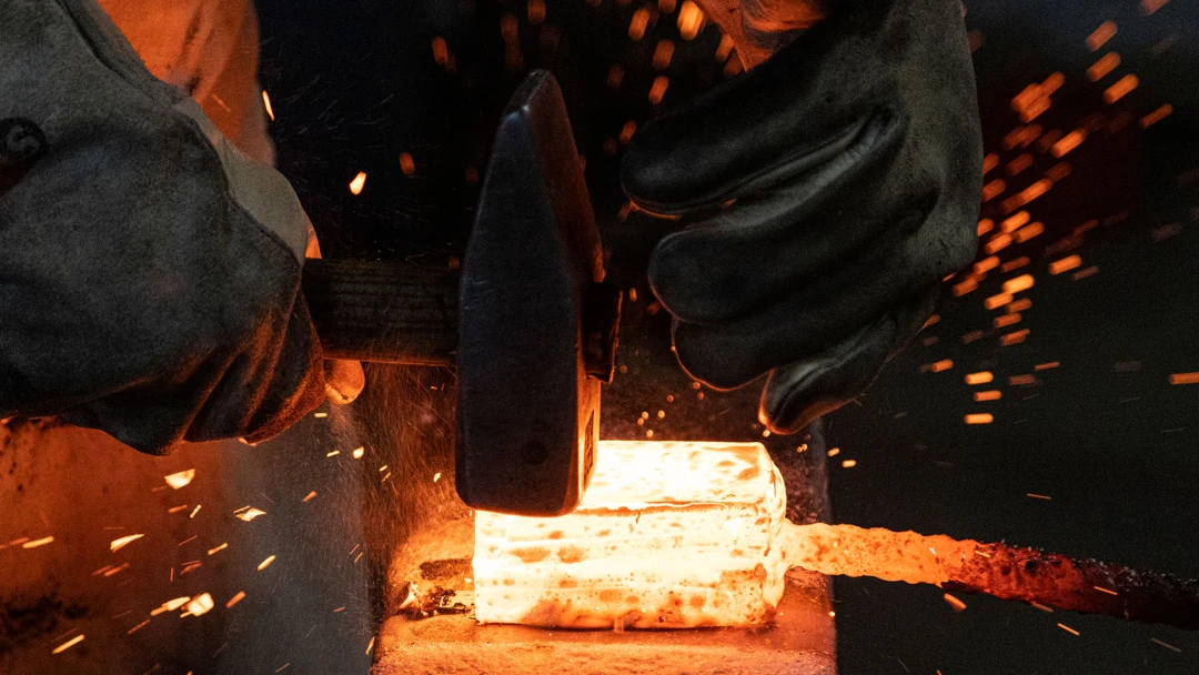 Hammer auf glühendem Stahl