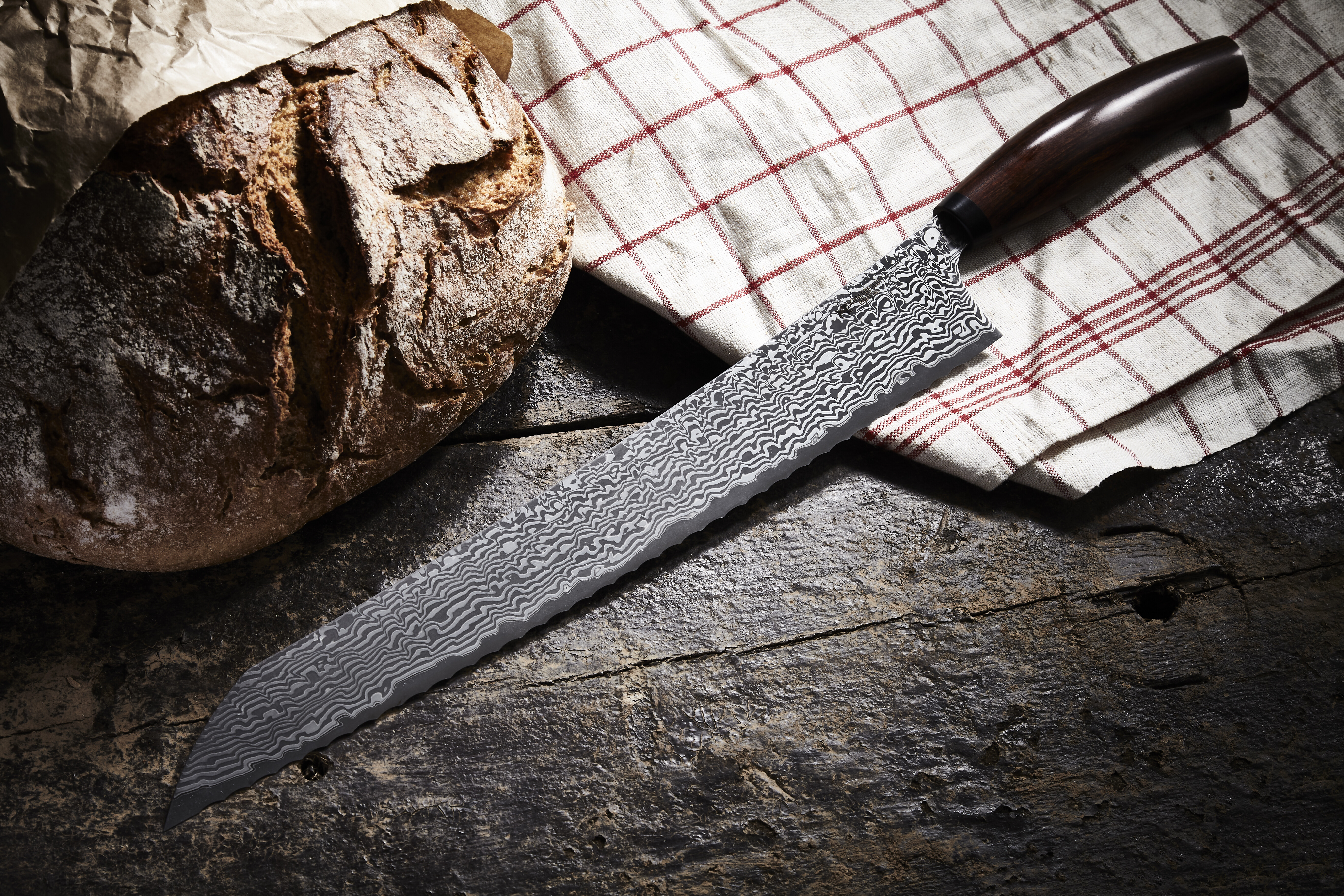 Ein gutes Brotmesser mit langer Klinge und Wellenschliff schneidet Brot mit harter Kruste